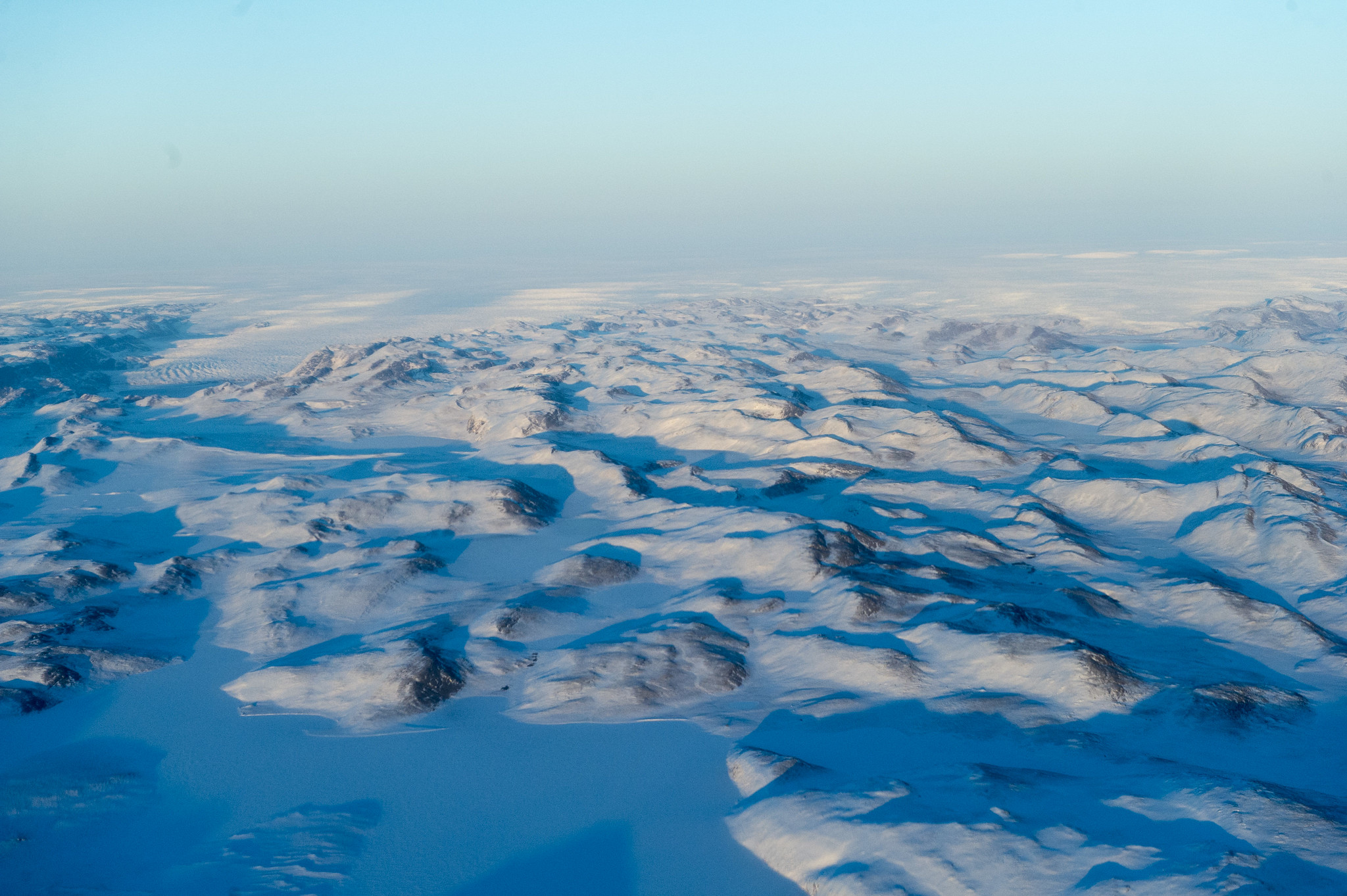 An aerial image of the Greenland ice sheet showing a vast landscape of glaciers.