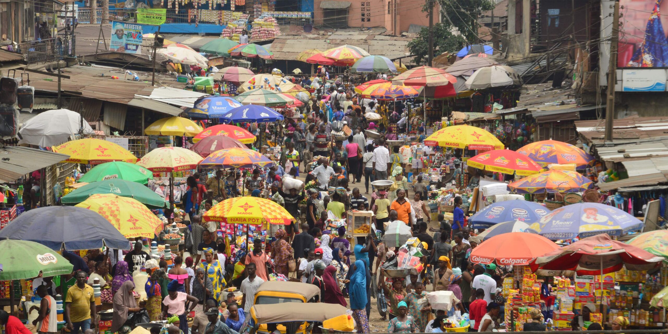 A busy market in Lagos, Nigeria with umbrellas and a very crowded street