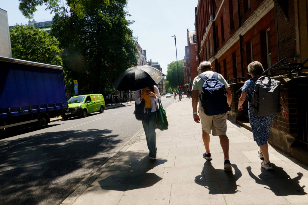 A person uses an umbrella to keep cool during a heatwave in London, England. June 22 2026. The UK’s Met Office issued a rare red extreme heat warning across parts of the country for this week.