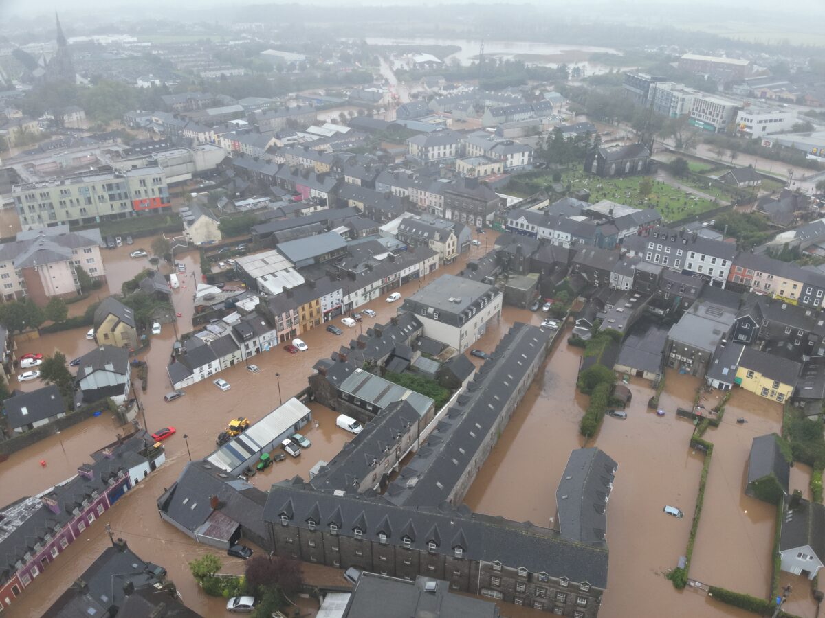 An aerial image of flooding in Midleton Ireland showing brown floodwaters, underwater cars and homes